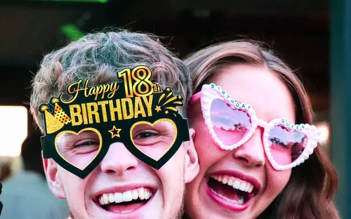 Przyjaciele w urodzinowych okularach z napisem Happy 18 Birthday